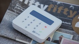 Auf der Straßenzeitung "fiftyfifty" liegt ein Gerät für die Zahlung mit Kreditkarte.