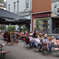 Besucher sitzen vor dem Filmforum Duisburg