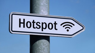 in weißes Schild am Pfahl einer Straßenlaterne mit der Aufschrift "Hot Spot" weist nach rechts.