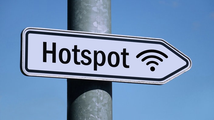 in weißes Schild am Pfahl einer Straßenlaterne mit der Aufschrift "Hot Spot" weist nach rechts.