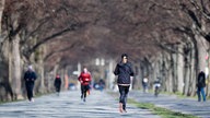 Jogger laufen durch einen Park im Winter. 
