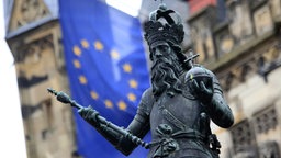 Eine Statue von Karl der Große mit einer Fahne der Europäischen Union vor dem Rathaus in Aachen.