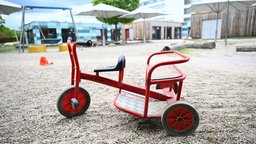 Spielgeräte stehen vor einer Kindertagesstätte