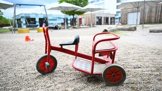 Spielgeräte stehen vor einer Kindertagesstätte