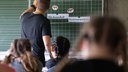 Ein Lehrer steht an der Tafel vor einer Schulklasse