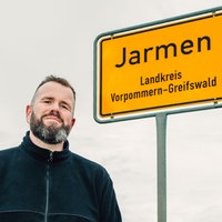 Monchi neben dem Ortsschild von Jarmen