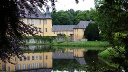 Schloss Dyck über den umgebenden Wassergraben hinweg fotografiert.