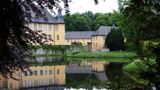 Schloss Dyck über den umgebenden Wassergraben hinweg fotografiert.