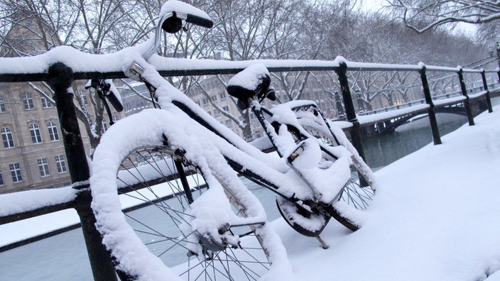 Ein zugeschneites Fahrrad steht auf der Königsallee in Düsseldorf