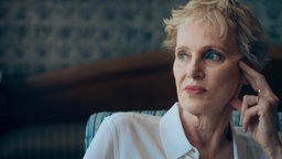 Siri Hustvedt in nachdenklicher Pose: Mit einer Hand stützt sie die linke Schläfe, dabei blickt sie in die Ferne.
