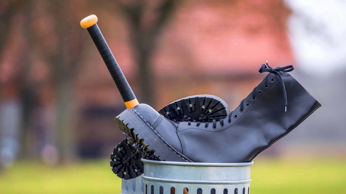 Springerstiefel und Baseballschläger im Abfalleimer.