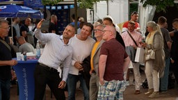Ulrich Siegmund, Spitzenkandidat der AfD in Sachsen-Anhalt, macht ein Selfie mit drei Männern. 
