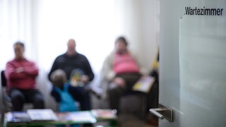 Patienten sitzen im Wartezimmer einer Arztpraxis. 