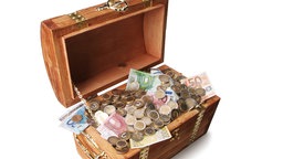 Eine hölzerne Truhe gefüllt mit Geld.
