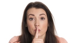 Zeigefinger auf Lippen