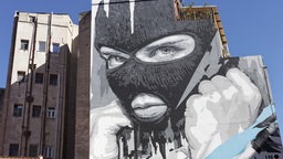 Ein Graffiti eines maskierten Mannes mit geballter Fraust 