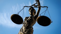Justicia hält ihre Waagschalen hoch