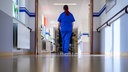 Krankenpflegerin schiebt einen Rollstuhl 