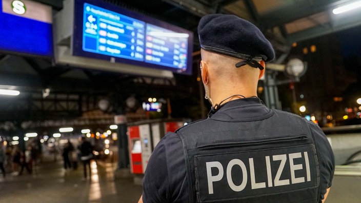 Ein Polizist steht am Bahnhof 