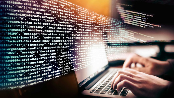 Symbolbild Sicherheit im Netz: Programmcode und Hände mit der Tastatur eines Computers