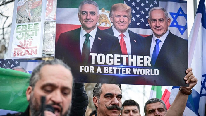 Ein Mann aus der iranischen Gemeinde in Rumänien hält während eines Protests vor der iranischen Botschaft ein Bild in die Höhe. 