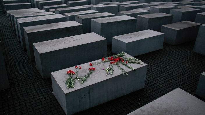 Nelken liegen auf einer Stehle des Holocaust Denkmals in Berlin