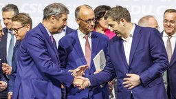 Markus Söder, Parteivorsitzender der CSU, Friedrich Merz (CDU), Kanzler in spe, und Lars Klingbeil, Parteivorsitzender der SPD, bei der Unterzeichnung des Koalitionsvertrages zwischen SPD, CDU und CSU. 