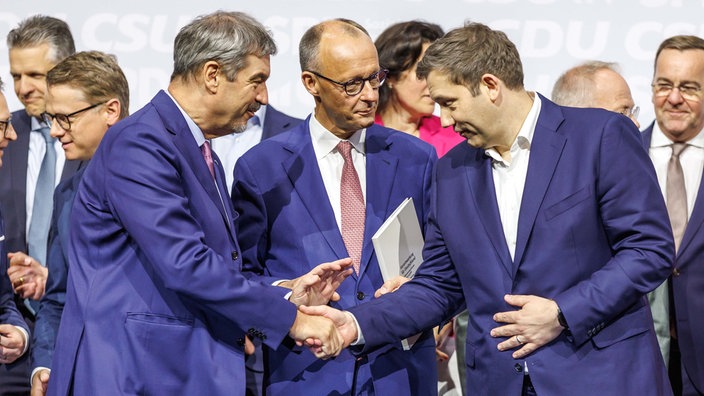 Markus Söder, Parteivorsitzender der CSU, Friedrich Merz (CDU), Kanzler in spe, und Lars Klingbeil, Parteivorsitzender der SPD, bei der Unterzeichnung des Koalitionsvertrages zwischen SPD, CDU und CSU. 