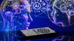 Im Vordergrund liegt ein Smartphone mit dem OpenAI-Logo, im Hintergrund futuristische Illustrationen.