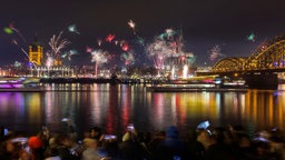 chaulustige haben sich auf dem Rheinboulevard eingefunden, um einen Blick auf den Kölner Dom und das Silvester-Feuerwerk zu erhaschen.