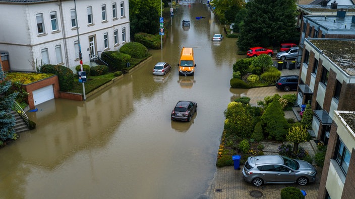 Autos stehen in den Wassermassen in einer überschwemmten Straße in Mönchengladbach-Rheydt.