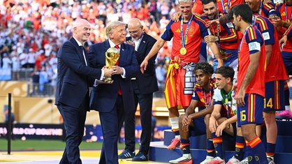 Trump und Infantino tragen den WM-Pokal gemeinsam zur Siegerehrung des WM-Finales.