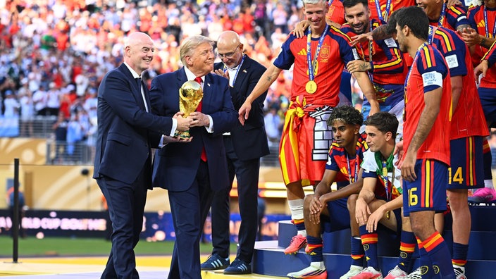 Trump und Infantino tragen den WM-Pokal gemeinsam zur Siegerehrung des WM-Finales.