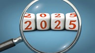 Schriftzug "2025" liegt unter einer Lupe.
