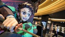 Eine lebensgroße Figur von Tanjiro Kamado, der Hauptfigur aus dem Anime "Demon Slayer" steht in einem Kino in Tokyo