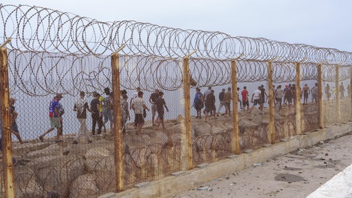 Geflüchtete hinter dem Grenzzaun in Ceuta an der Grenze zwischen Spanien und Marokko.