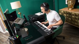 Ein Mann arbeitet in einer Wohnung in Hamburg in seinem Musikstudio 