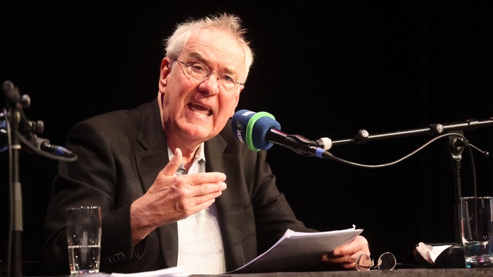 Jörg Maurer vspricht in ein WDR Mikro auf der Bühne vom Pantheon in Bonn
