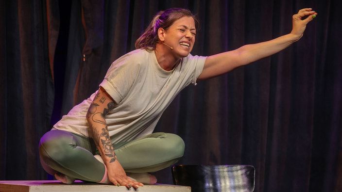 Lisa Christ sitzt auf einem Tisch auf der Bühne im Theater am Dom