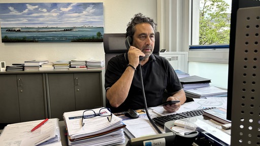 Roberto Spranzi telefoniert an seinem Arbeitsplatz