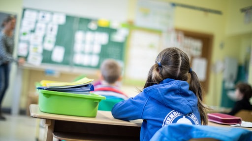 Schülerinnen und Schüler einer Grundschule sitzen in ihrem Klassenraum