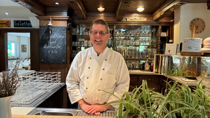 Bernhard Schwermer hinter der Theke eines Restaurants.