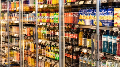 In einem Regal stehen Softdrinks unterschiedlicher Marken