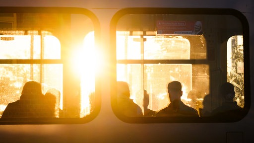 Der Sonnenaufgang durch die Fenster einer Stadtbahn