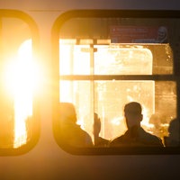 Der Sonnenaufgang durch die Fenster einer Stadtbahn