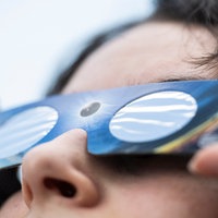 Eine Angestellte eines Fotofachhandelsgeschäfts hat eine Sonnenfinsternis-Brille an