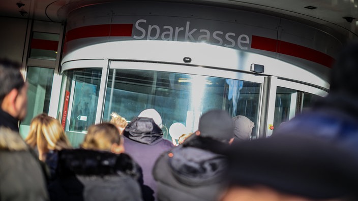 Wartenden Kunden stehen vor der Sparkassenfiliale in Gelsenkirchen-Buer
