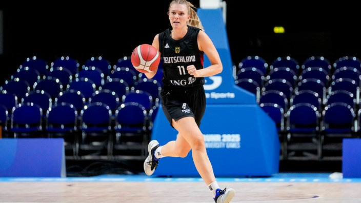 EIne deutsche Basketballspielerin vor leeren Sitzen.