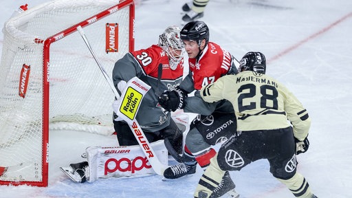 Haie-Goalie Janne Juvonen (l.) und Veli-Matti Vittasmäki gegen Ross Mauermann von den Grizzlys Wolfsburg.