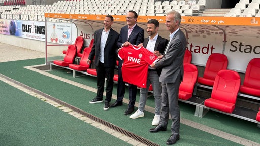 Marc-Nicolai Pfeifer (Vorstandsvorsitzender Rot-Weiss Essen), Markus Krebber (Vorstandsvorsitzender RWE), Alexander Rang (Vertriebschef Rot-Weiss Essen) und Michael Marhofer (Geschäftsführer ifm) halten ein rotes Trikot mit der Aufschrift "RWE"